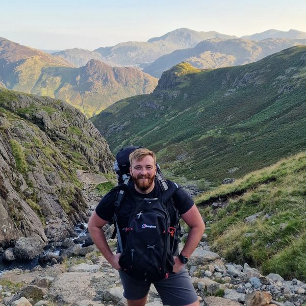 A man hiking on a rocky mountain trail with a backpack.
