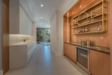 Sleek modern hallway with built-in bar and white cabinetry.