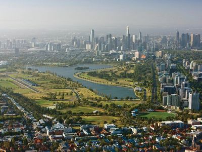 Aerial view of a cityscape with water bodies and green spaces.