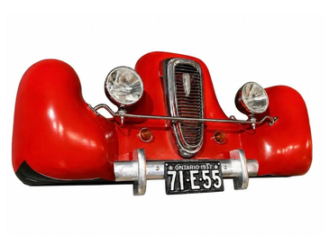 Front view of a vintage red car bumper and grill.