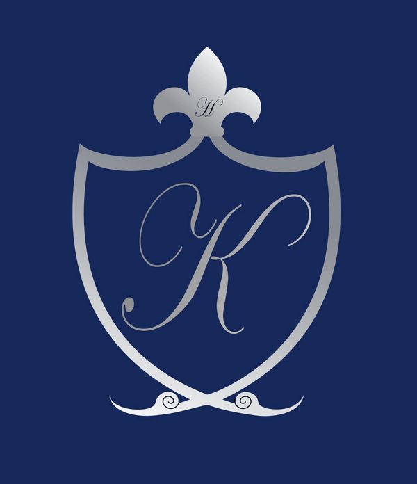 Silver shield emblem with letter K on dark blue background.