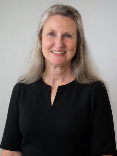 Smiling woman with long blonde hair in a black top.