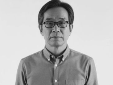 Serious middle-aged man wearing glasses and a buttoned shirt.