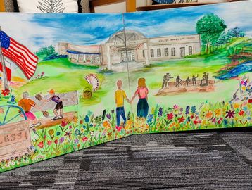 Colorful mural depicting community, nature, and American pride with people, flowers, and a historic building.