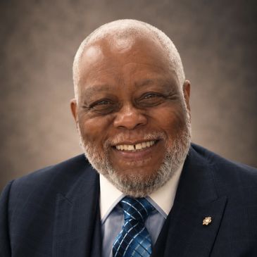 Smiling older man in suit and tie.