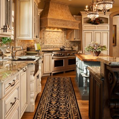 Warm, cozy, elegant kitchen. Angle shows two ovens and a large range