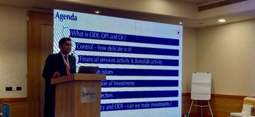 A man presents a financial services agenda at a conference room podium.