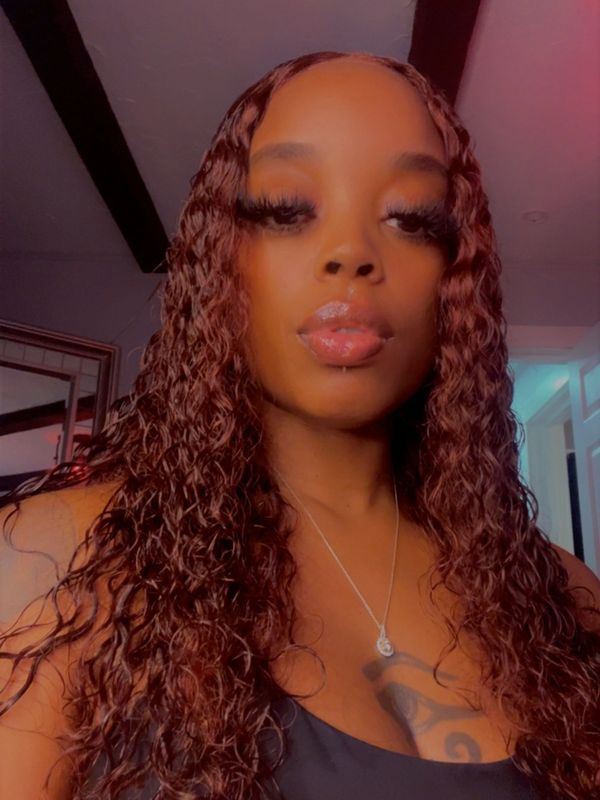Woman with long curly hair and glossy lips.