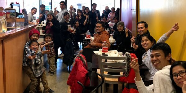 Large happy group dining together in a restaurant.