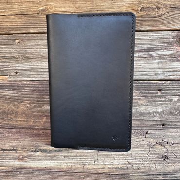 Black leather wallet on a rustic wooden surface.