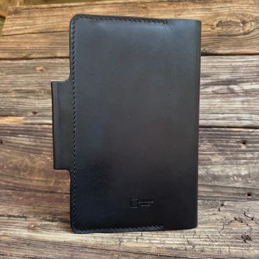 Black leather wallet on wooden surface.