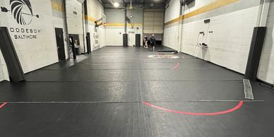 Empty indoor gym with black flooring.