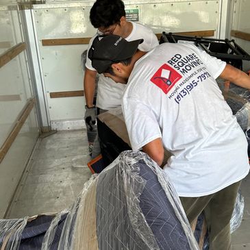 Licensed & insured movers in Wesley Chapel carefully wrapping sofa