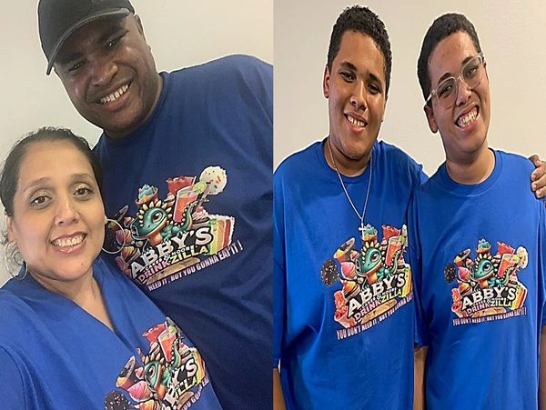 Four people wearing matching blue Abby's Drinkzilla shirts, smiling.
