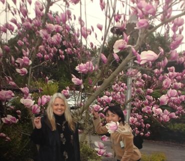 two people standing under a blooming tree