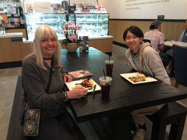 two people sitting at a table with plates of food