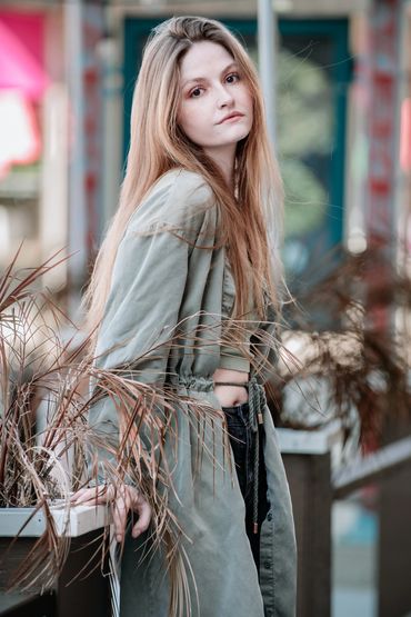 Girl posing outdoors, wearing a coat