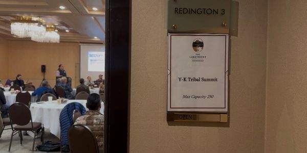 Conference room hosting the Y-K Tribal Summit with attendees seated and a speaker at the front.