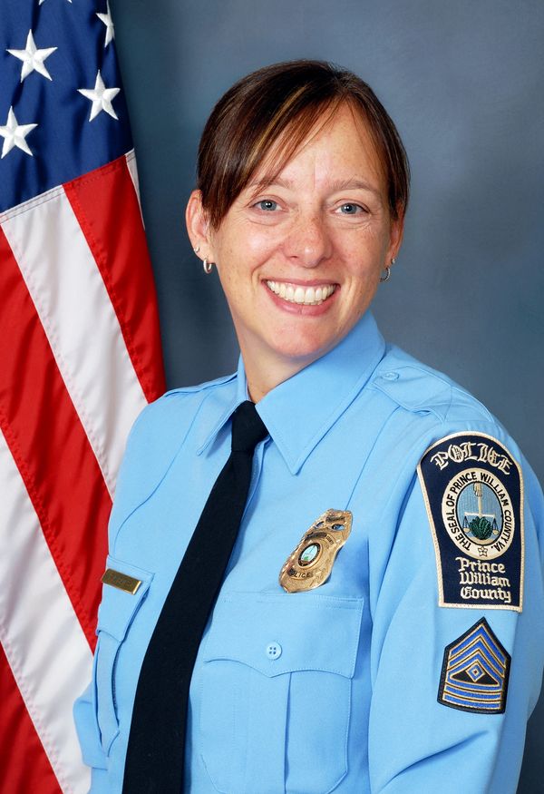 Female police officer in Prince William County uniform smiling.
