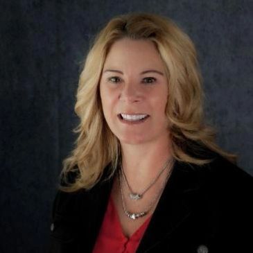 Smiling woman with blonde hair in professional attire.