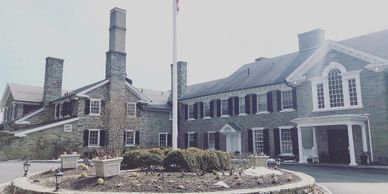 old stone clubhouse and a flag pole outside Manufacturers Country Club in southeastern Pennsylvania 