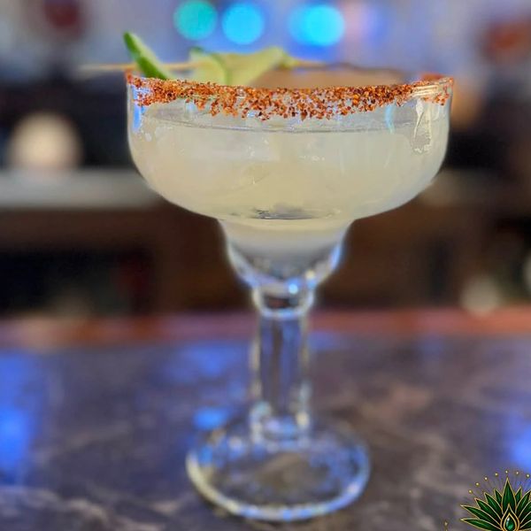 Classic Margarita cocktail with a chili rim on a marble table.