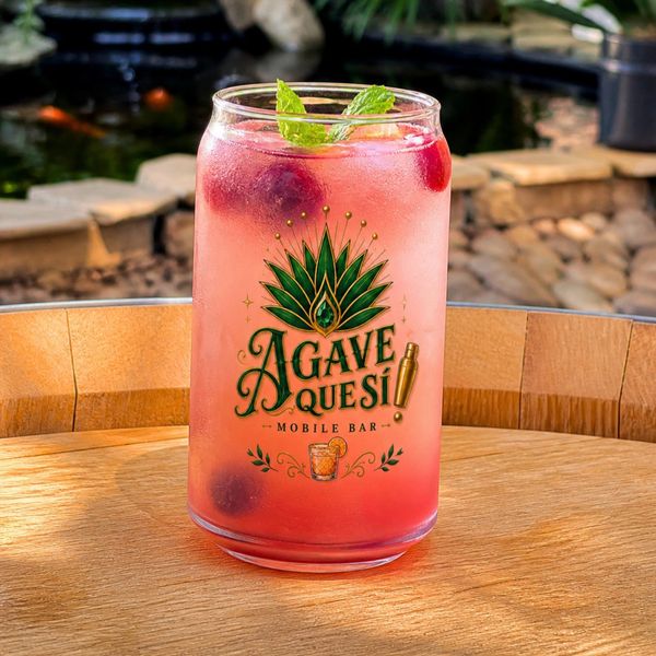 Pink Berry Mojito in a glass with Agave Quesi logo, garnished with mint leaves.