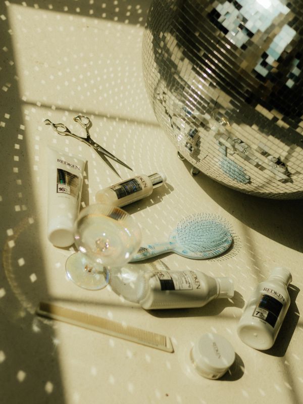 Hair care products and tools with disco ball reflections.