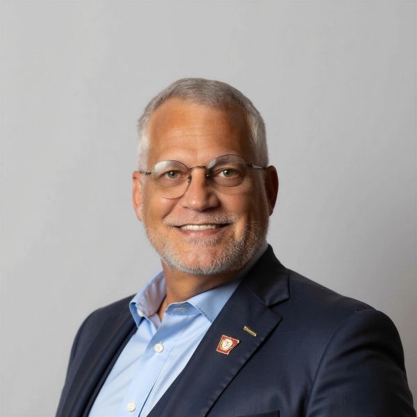 Smiling middle-aged man in glasses and a suit jacket.
