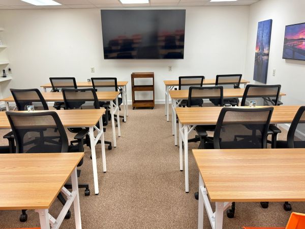 Modern classroom with desks and a large TV screen.
