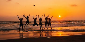 Happy group of travelers on the beach