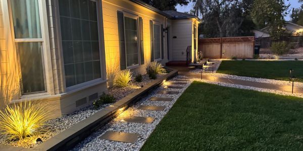 Outdoor pathway lighting along a house with stone steps.
