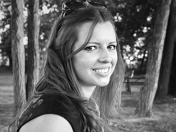 Becky Bates sitting outdoors at a picnic table in a park.