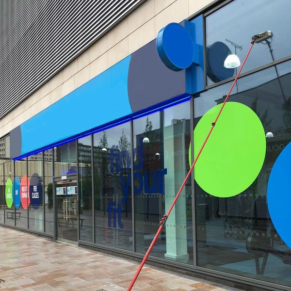 A window cleaning pole against a shop front