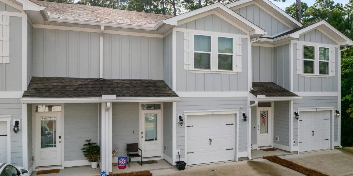 Modern grey townhouses with white trim and garages.