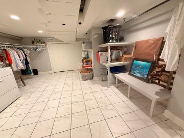 A clean, spacious basement room with tiled floor and organized storage.