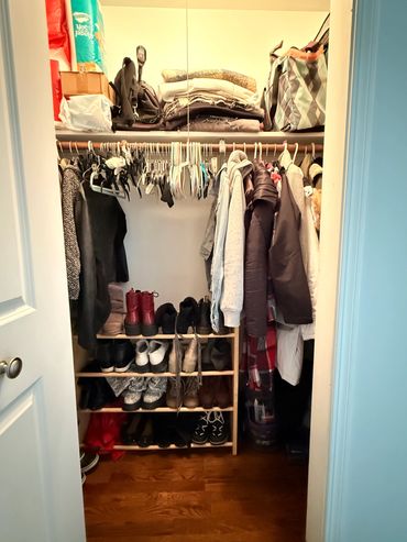 Organized closet with hanging clothes and shoes neatly arranged.