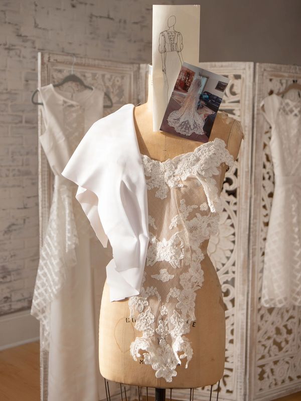 A dress form with bridal fabric draped on it and fashion sketches pinned to it in Winston Salem.
