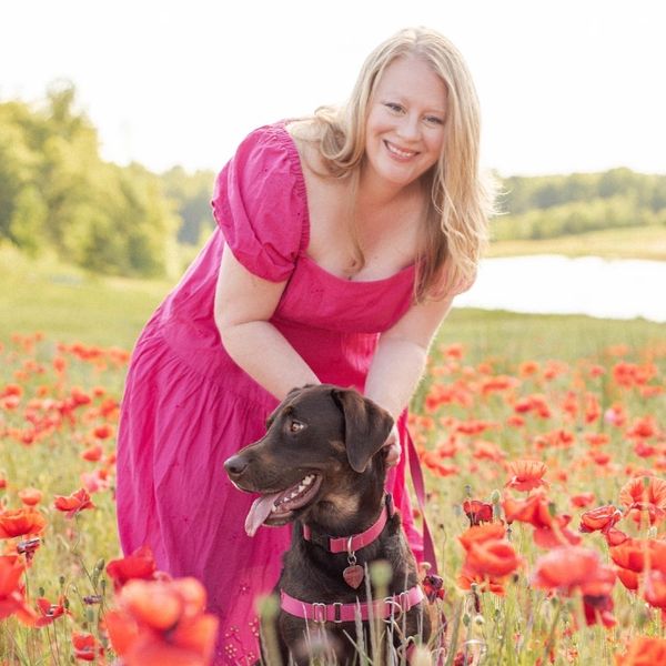 A woman with a chocolate lab in a field of Poppies in Winston Salem NC