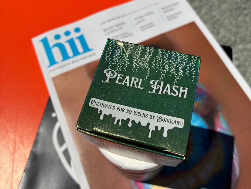 Green box of Pearl Hash on a magazine.