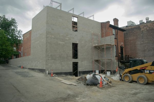 New building under construction with scaffolding and construction equipment.