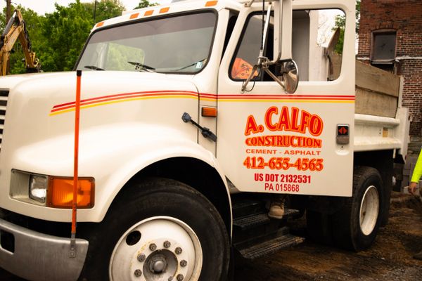 White construction truck with company branding and contact information.