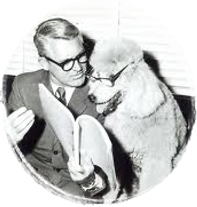 Man and poodle both wearing glasses, reading a book together.