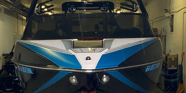 Front view of a sleek blue and black boat in a garage.