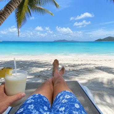 Relaxing on a tropical beach with a drink.