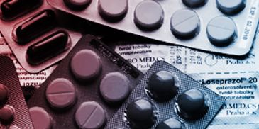 Various blister packs of medication pills on a surface.