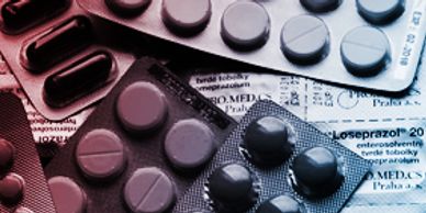 Various blister packs of pills arranged on a medical leaflet.