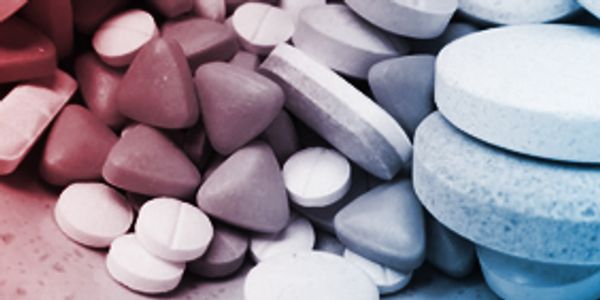 Various shaped and colored pills clustered together.