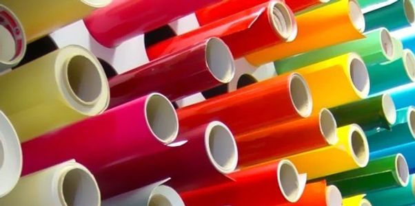 Multiple colored vinyl wrap rolls, ready to be used in a sign shop. 
