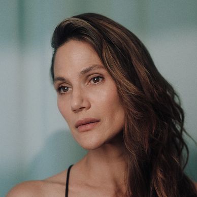 Portrait of a woman with long brown hair looking away.